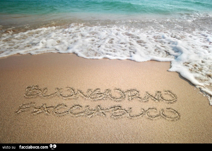 Buongiorno facciabuco scritto sulla sabbia del mare